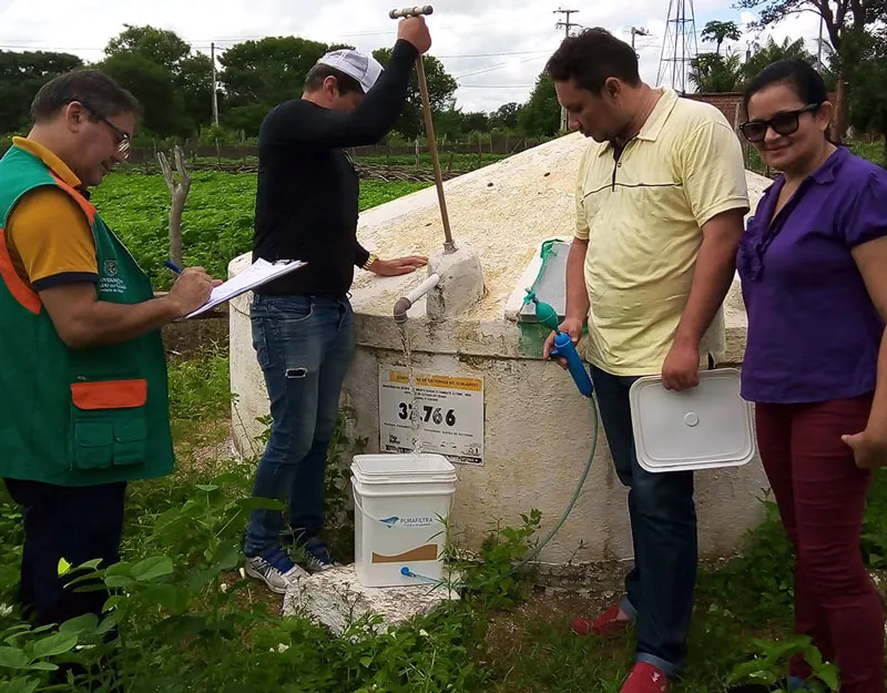 Equipe do Projeto Água Boa com a família ao lado da cisterna